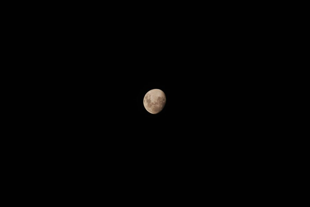 A clear view of the moon's surface in the night sky, capturing detailed lunar features.