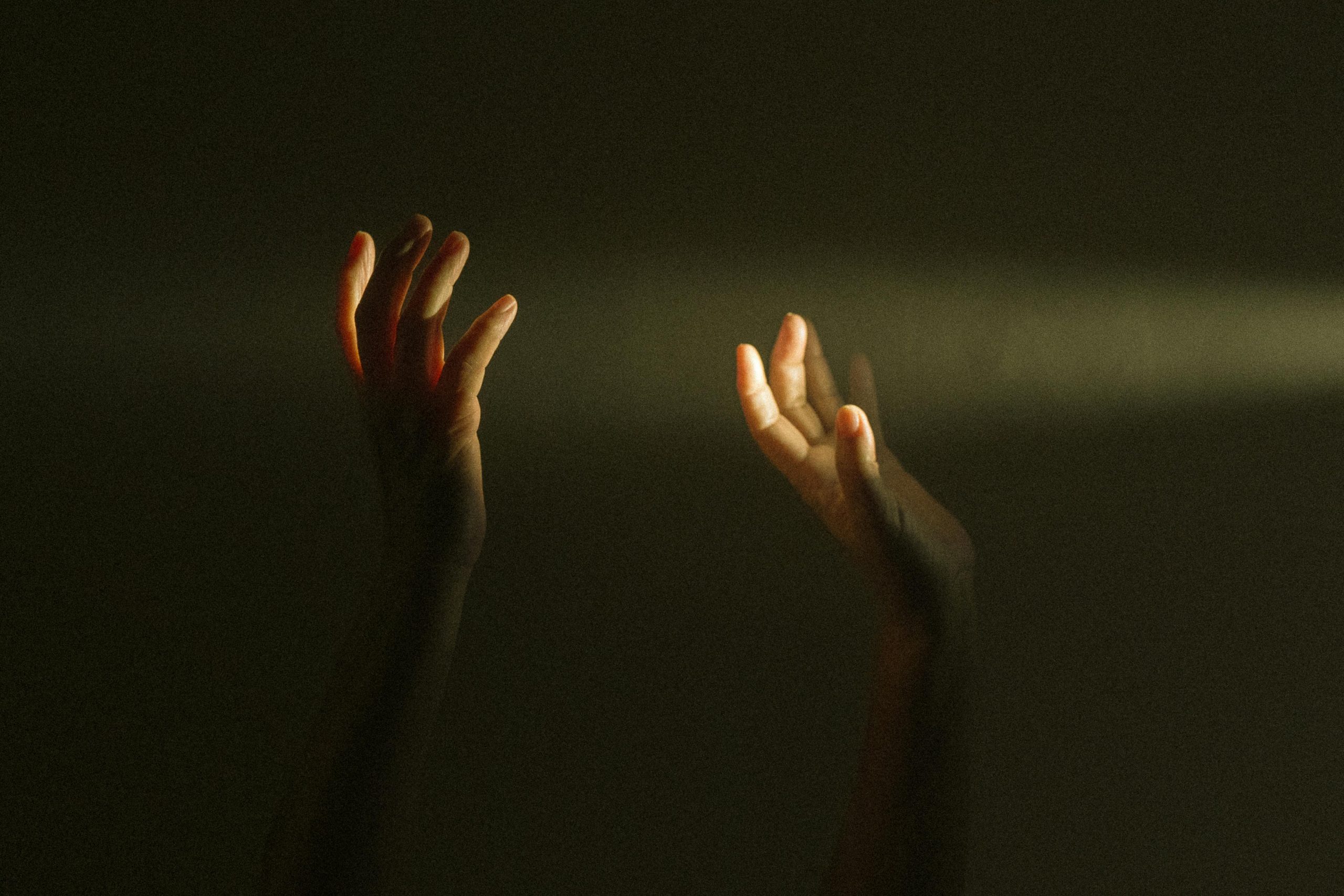 Expressive hands reaching towards a ray of light symbolize hope and mental resilience.